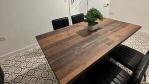 Una sala de conferencias con una mesa de madera, sillas negras, una planta en maceta y alfombra estampada.