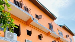 A multi-story building with balconies, air conditioning units, and satellite dishes. - Akpe Cultural Center and Hotel (Accra)