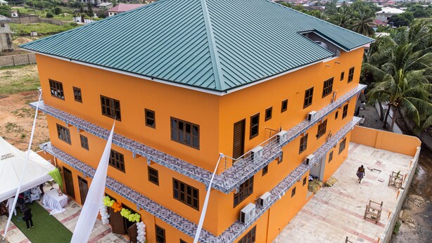 A multi-story building with a green roof, multiple balconies, and a courtyard. - Akpe Cultural Center and Hotel (Accra)