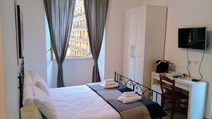 Une chambre bien rangée, avec un lit, un bureau, une chaise et un téléviseur.