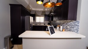 A modern kitchen with dark cabinets, a white countertop, and pendant lighting. - LnD Villa! Lovely gated community, 24 hrs security, amazing view, and pool  (Ocho Rios)