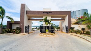 A hotel entrance with a modern design, featuring a prominent sign and a gated driveway. - LnD Villa! Lovely gated community, 24 hrs security, amazing view, and pool  (Ocho Rios)