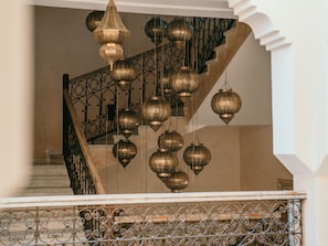 A staircase with ornate metal railings and hanging lanterns.
