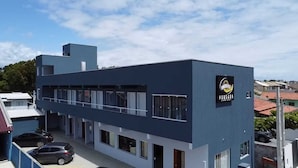 A modern building with a flat roof and a sign that reads "POUSADA".