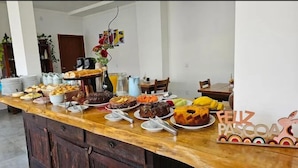 A breakfast buffet with various food items and a 'FELIZ PASCOA' sign.