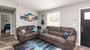 A living room with two brown leather sofas, a blue and white abstract rug, and a guitar leaning against the wall. - Cozy Lake Cumberland Retreat with hot tub, just above Jamestown Marina!


 (Jamestown)