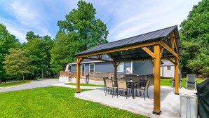 A covered patio with outdoor furniture, a grill, and a house in the background. - Cozy Lake Cumberland Retreat with hot tub, just above Jamestown Marina!


 (Jamestown)