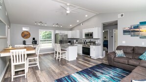 A modern kitchen with white cabinets, stainless steel appliances, and a dining area with a wooden table and white chairs. - Cozy Lake Cumberland Retreat with hot tub, just above Jamestown Marina!


 (Jamestown)