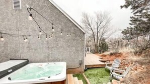 Ein Whirlpool in einem Garten mit einer Holzterrasse und Gartenmöbeln.