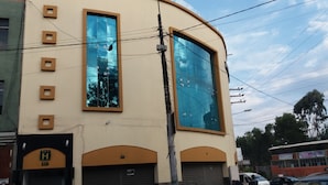 A building with large windows, a garage door, and a visible sign with the letter "H".
