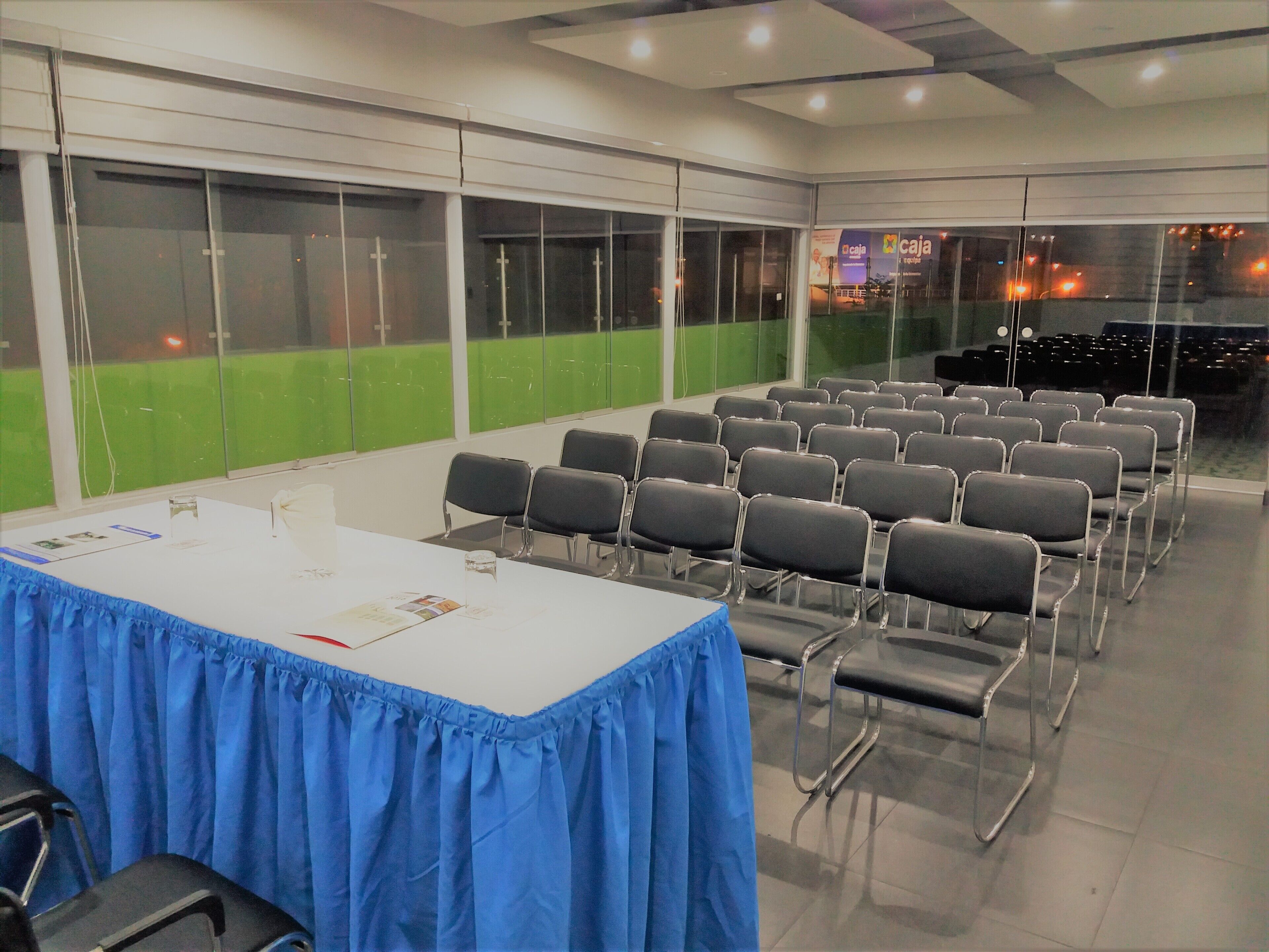 A conference room with a long table, chairs, and large windows.