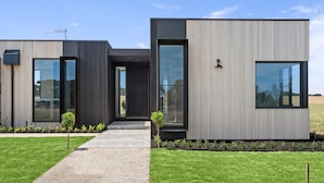 Un edificio moderno, de varias secciones, con grandes ventanales y un diseño minimalista.