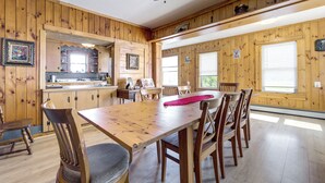 Interior de madera con una mesa de comedor, sillas y un ventilador de techo.