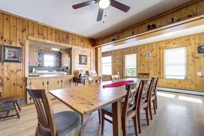 Un intérieur en bois avec une table à manger, des chaises et un ventilateur de plafond.