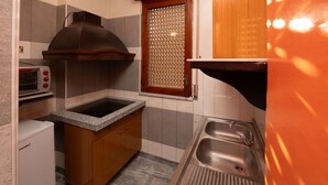 A compact kitchen with a built-in stove, a microwave, and a sink.