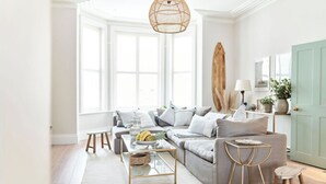 Una sala moderna con sofá, mesa de centro y lámpara colgante.