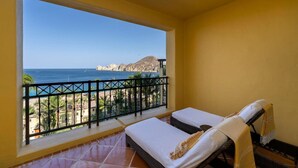 A balcony with two beds, a view of the sea, and a mountain in the background. - Hacienda Beach Club, Beachfront, 5-Star, Luxury (Cabo San Lucas)