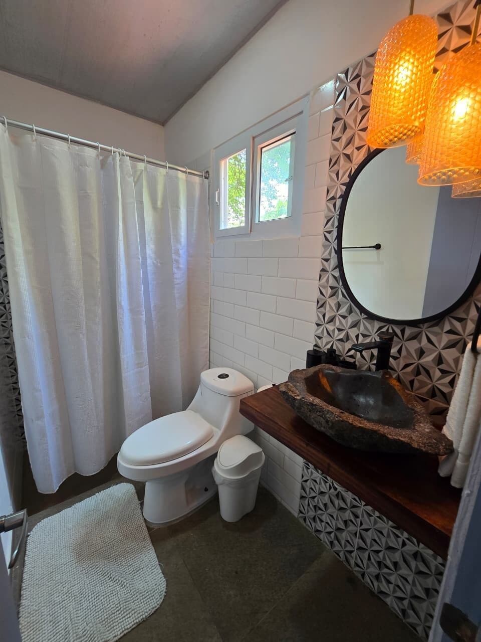 A bathroom with a toilet, sink, and shower curtain.