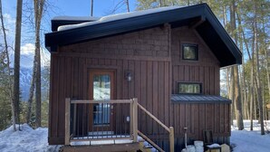 A wooden cabin with a front door, a small porch, and a window. - Aspen House, the "not so tiny" house! (Golden)