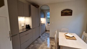 Eine Küche mit Esstisch, Fenster und Tür.