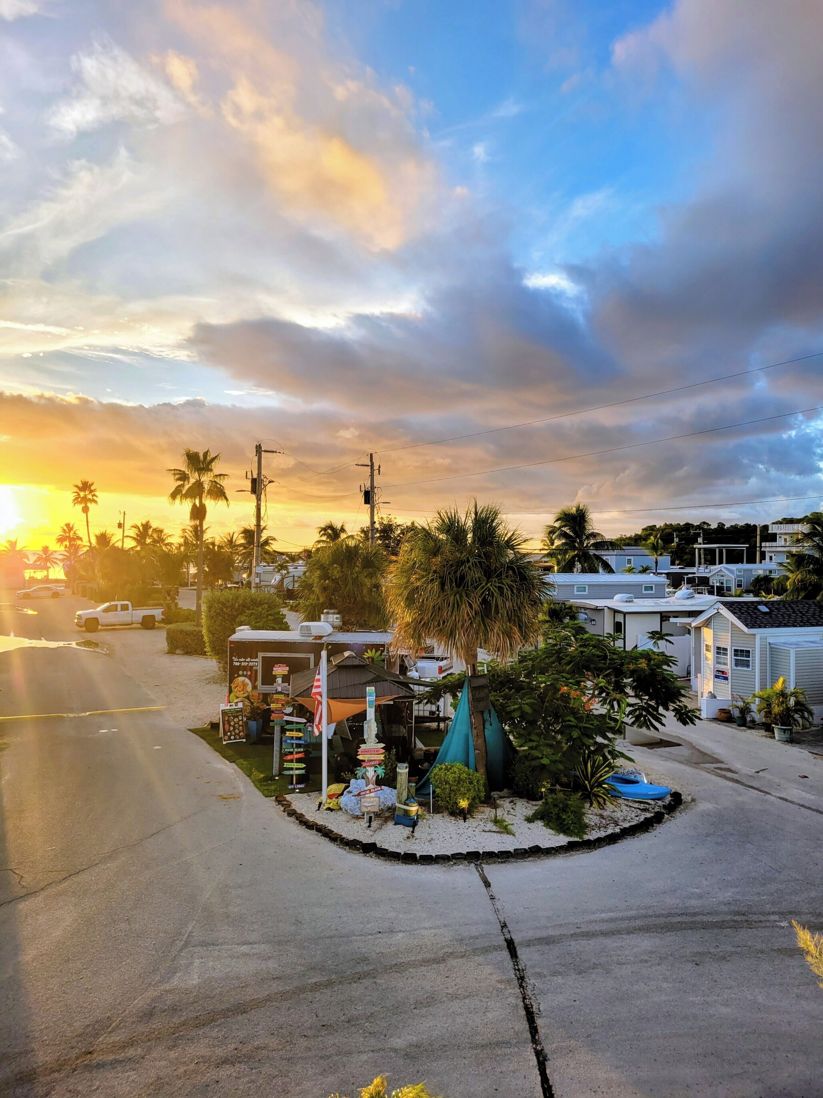 Zona costera con casas móviles, palmeras y una playa.
