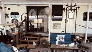A covered outdoor seating area with a sofa, chairs, and a coffee table. There is a fan, a chandelier, and nautical decorations. - Book now! Special prices for the holidays and 2026 rentals! (Key Largo)