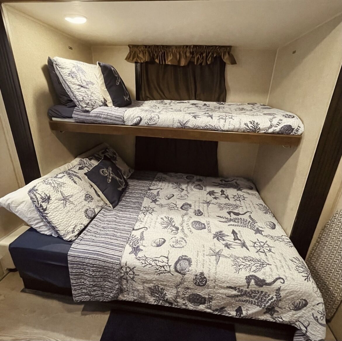 Un lit superposé avec une parure de lit sur le thème de la marine.