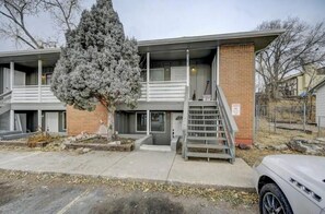 A two-story building with a brick facade, a covered front porch, and a staircase leading to the entrance. - Western Homefront (Vista Creek Pt)