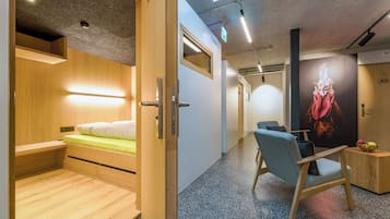 Camera d'albergo moderna con un letto in legno, una scrivania, una sedia e un grande quadro di un gallo appeso al muro.