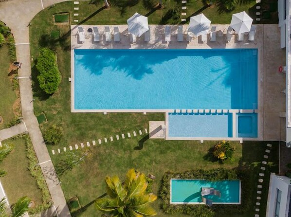 Luftaufnahme eines Poolbereichs mit Liegestühlen und einem kleineren Pool.