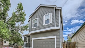 A two-story residential building with a grey exterior and white trim, featuring a garage with the number 3045. - 4 bedroom fully Fenced 2+ Garage Pkg & Air Cond pet friendly  (Colorado Springs)