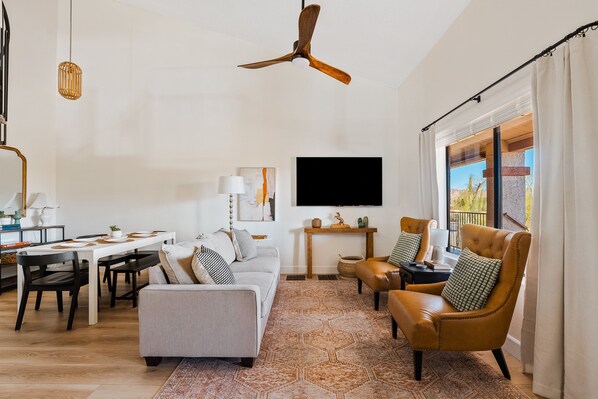 TV connectée, cheminée, livres, écrans d'ordinateur