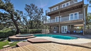 A two-story building with a pool and wooden deck. - Private Pool/Pier - Beautiful Bayfront Property! (Gulf Shores)