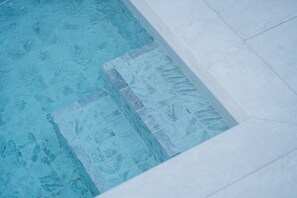 A swimming pool with clear water and tiled steps leading into it. - Luxury Stay – La Mer Noosa Apartment 09 (Noosa Heads)