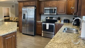 A kitchen with granite countertops, stainless steel appliances, and wooden cabinets.