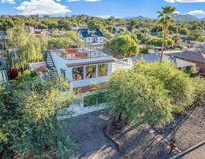 A residential area with a two-story house featuring a balcony, a staircase, and a view of the surrounding neighborhood. - Central Home, Rooftop, Hot Tub, Arcade - 1.3 miles to UofA / 9 min to downtown (Tucson)