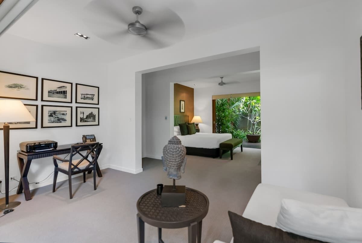 A modern living room with a desk, chair, and artwork on the wall.