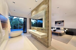 Un bagno moderno con una vasca freestanding, un grande specchio e un doppio lavabo.