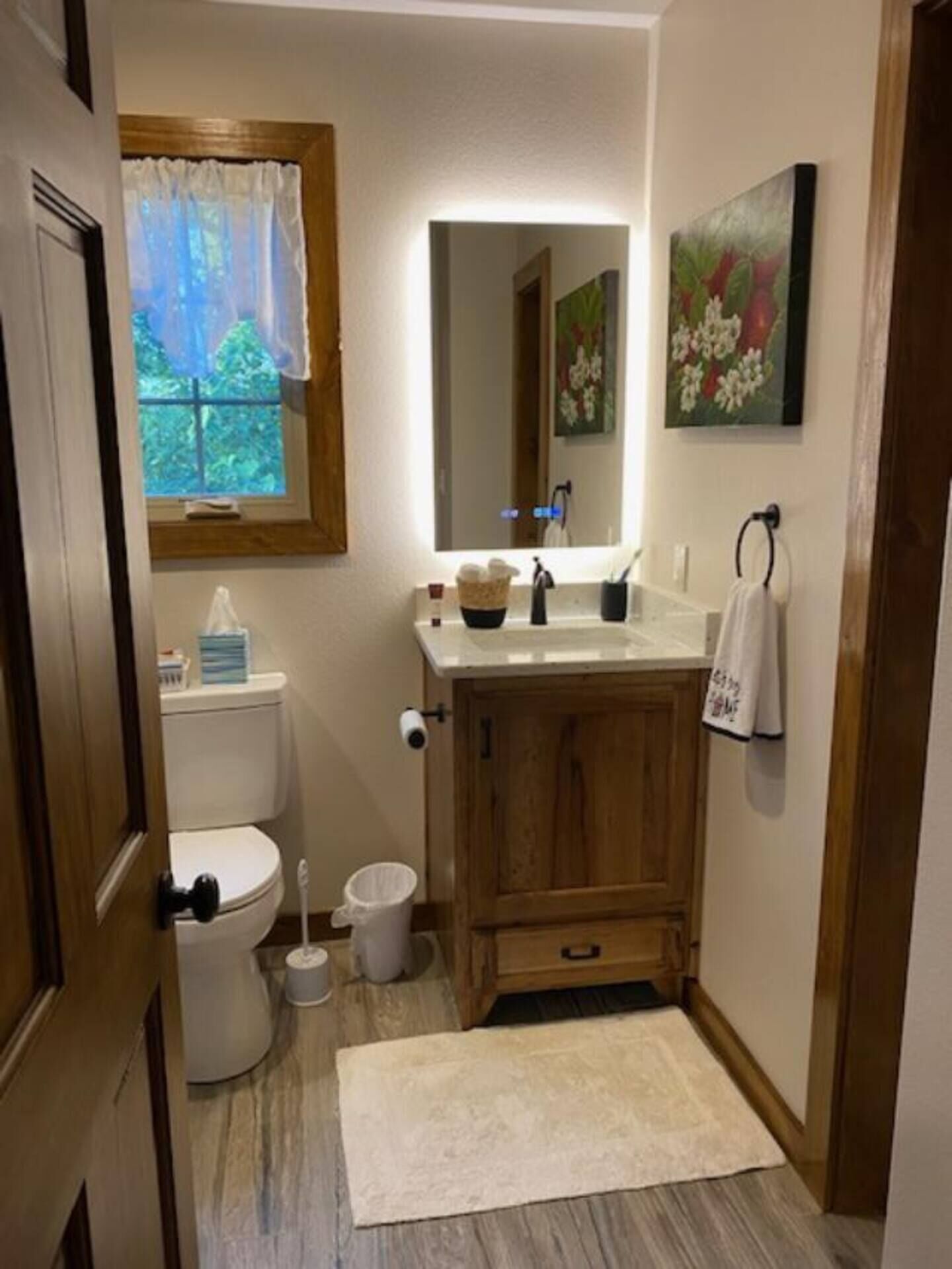 Un baño pequeño con inodoro, lavamanos y espejo.