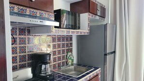 A kitchen with a coffee maker, a microwave, and a refrigerator. - Tiny Condo PB 5 at Vista Encantada! 1 Bedroom, kitchen, pool, incredible views!  (El Divisadero)