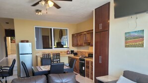 A compact living space with a kitchenette, a dining area, and a seating area with leather sofas. - 1 Bedroom Condo with Incredible Ocean View in Nayarit Jungle #404 (El Divisadero)