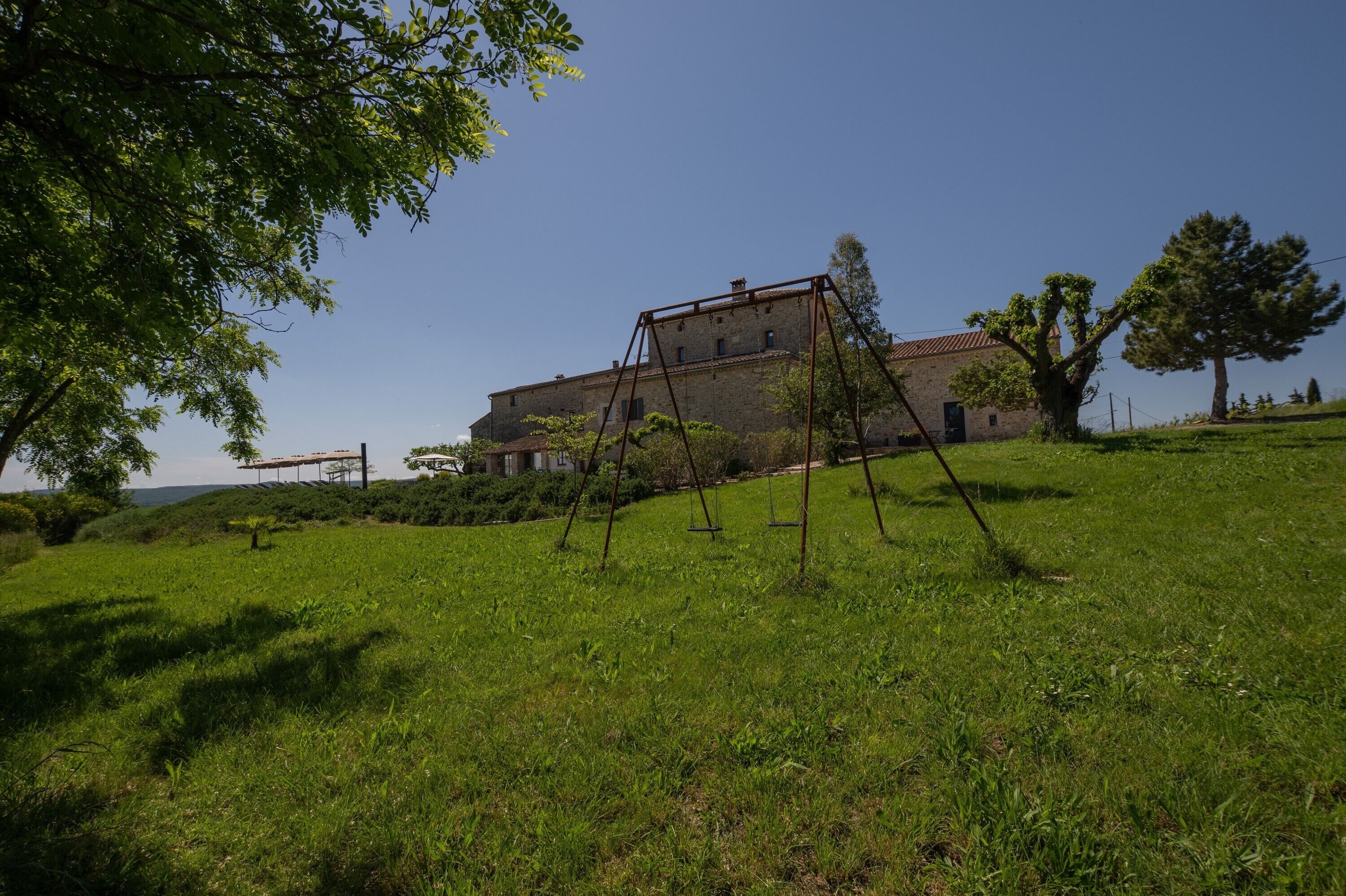 A grassy area with a swing set and a building with multiple windows in the background.