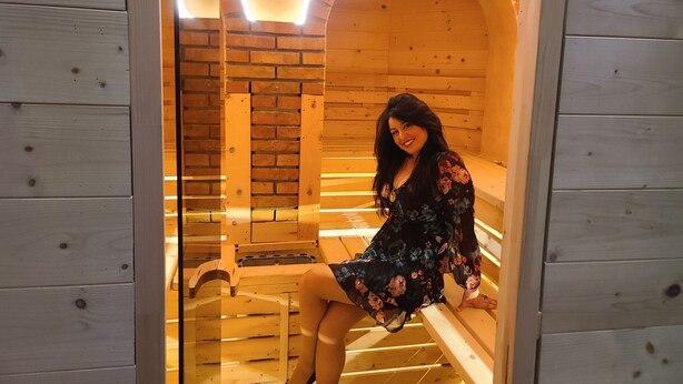 Un sauna avec des bancs en bois et un mur en briques.