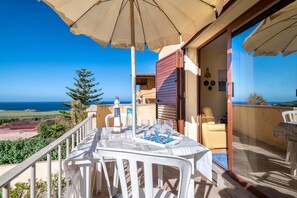 A balcony with a table set for dining, a chair, and a view of the ocean. - Apartment 'Casa Al Mare' with Sea View, Private Terrace and Air Conditioning (Valledoria)