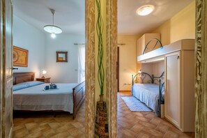 A bedroom with a bed, bedside table, lamp, and a decorative vase. - Apartment 'Casa Al Mare' with Sea View, Private Terrace and Air Conditioning (Valledoria)