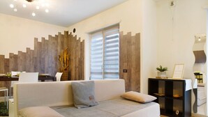A modern living room with a sofa, a coffee table, and a bookshelf. - Apartment 'Appartamento Da Jenny' with Mountain View, Balcony and Wi-Fi (aosta)
