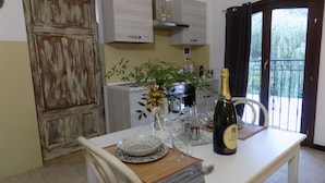 A dining area with a table set for two, a bottle of champagne, and a vase with flowers. - relais Cà del rio (Pianoro)