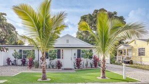 A two-story house with a white exterior, a front porch, and a well-maintained lawn. - Heated Pool + Backyard: North Palm Beach Retreat! (North Palm Beach)