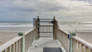 A wooden boardwalk leading to a beach with a metal gate. - North Topsail Beach Condo in Resort-Style Complex! (North Topsail Beach)