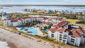 A resort with multiple buildings, a central pool, and a beach. - North Topsail Beach Condo in Resort-Style Complex! (North Topsail Beach)